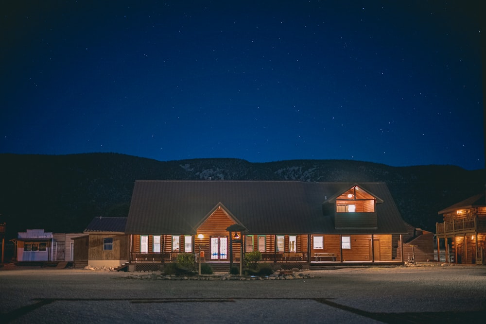 a house lit up at night with mountains in the background