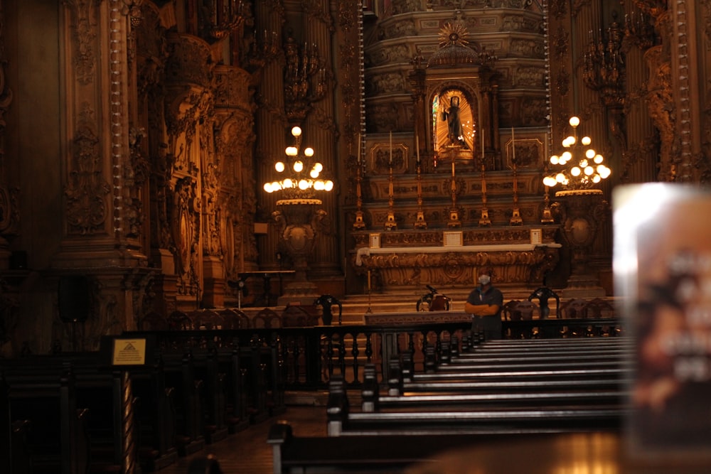 a church with pews and chandeliers in the middle of it