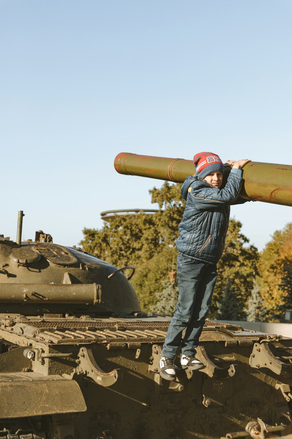 a man standing on top of a tank holding a large object