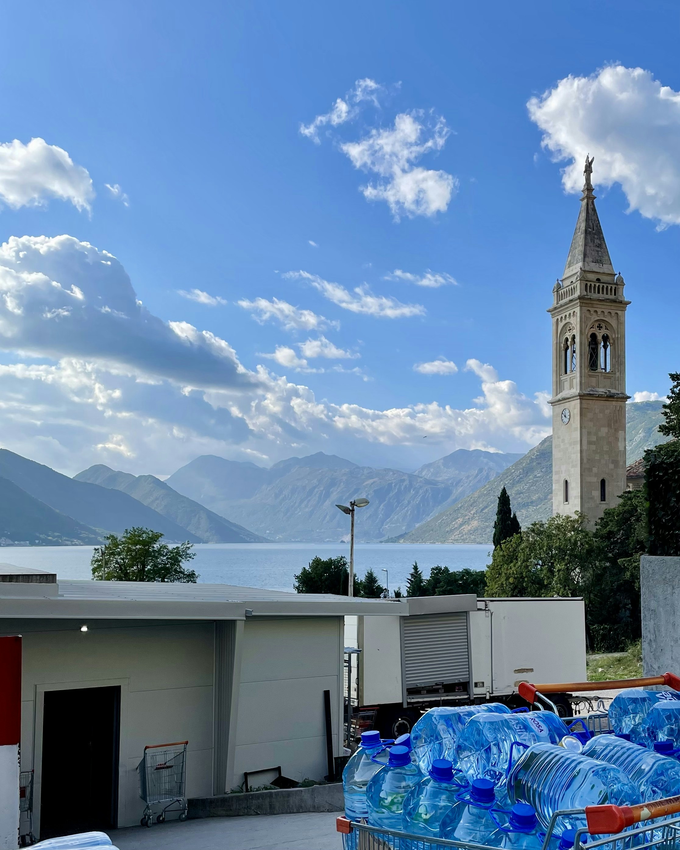 a shopping cart full of bottled water in front of a church