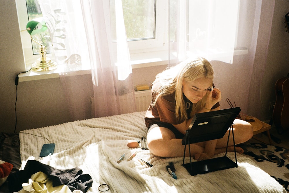 a woman sitting on a bed talking on a cell phone