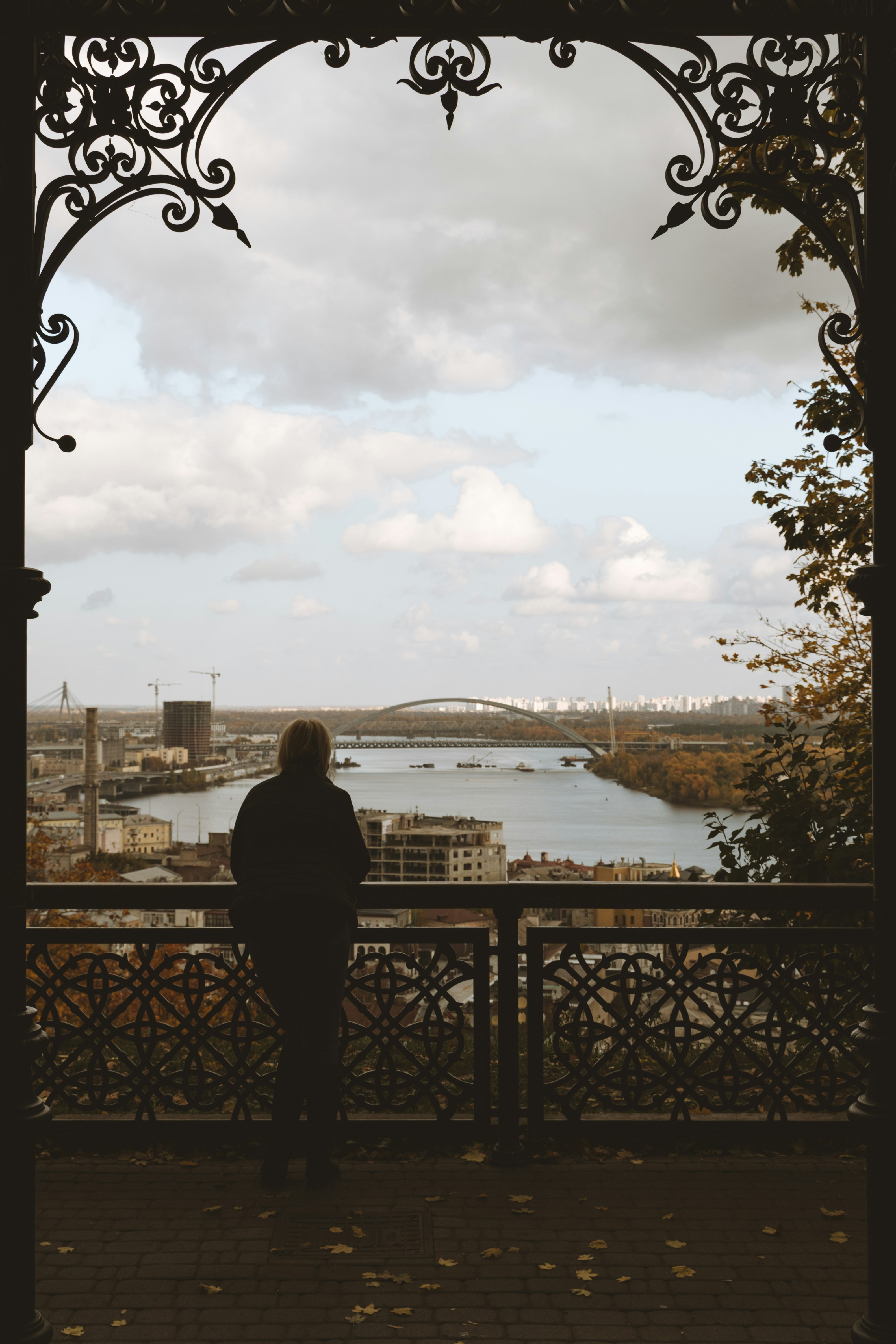 una persona in piedi su un balcone che guarda fuori un fiume