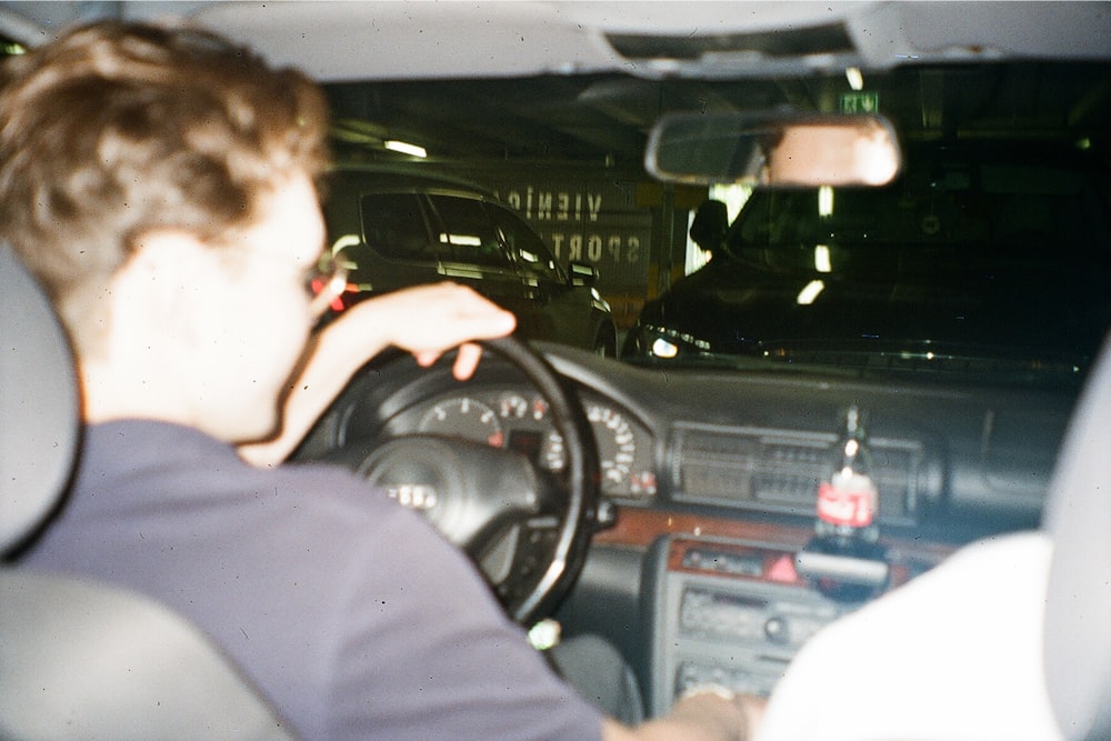 a man driving a car in a parking lot