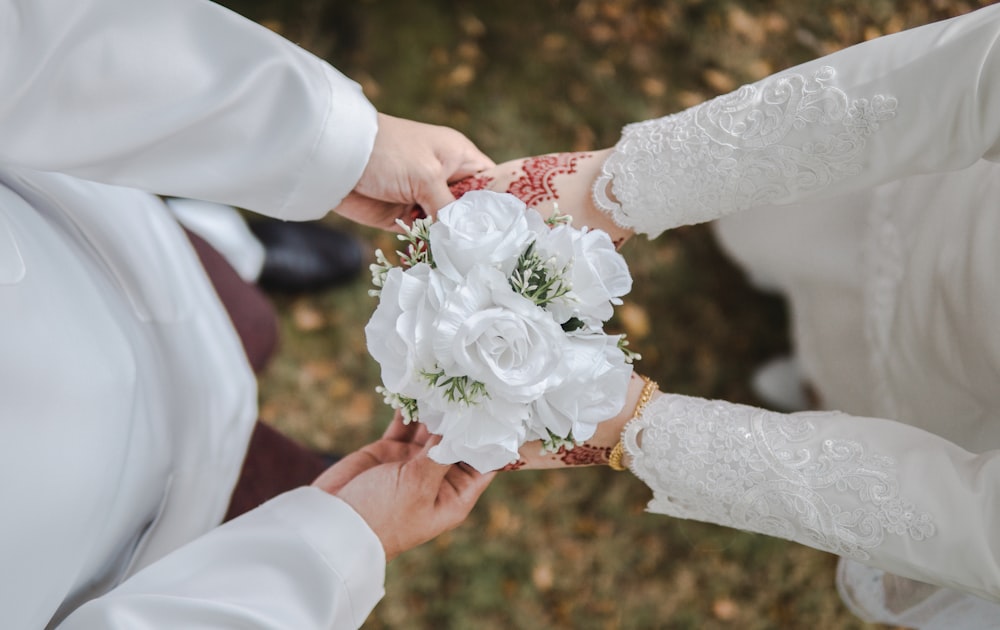 a close up of a person holding a bouquet of flowers