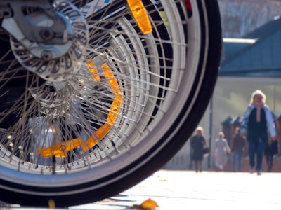Set of shiny bike wheels with spokes reflecting sunlight on a city street
