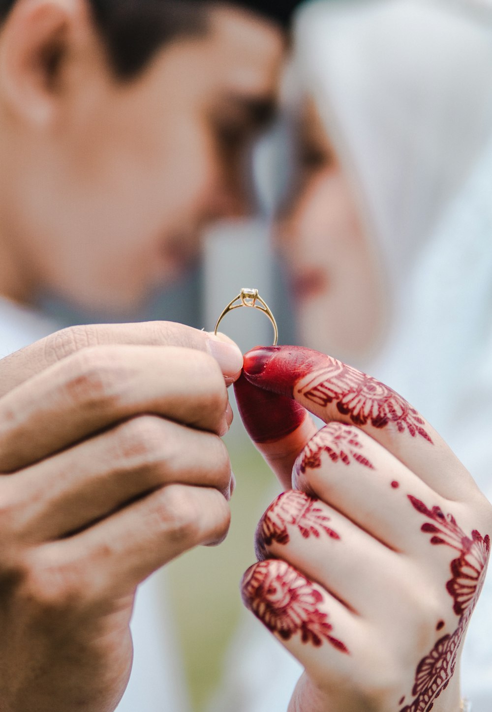 a bride and groom holding a wedding ring