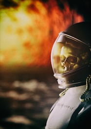 A futuristic scene featuring an astronaut helmet with a visible skull inside, set against an intense background that suggests a fiery or explosive environment.