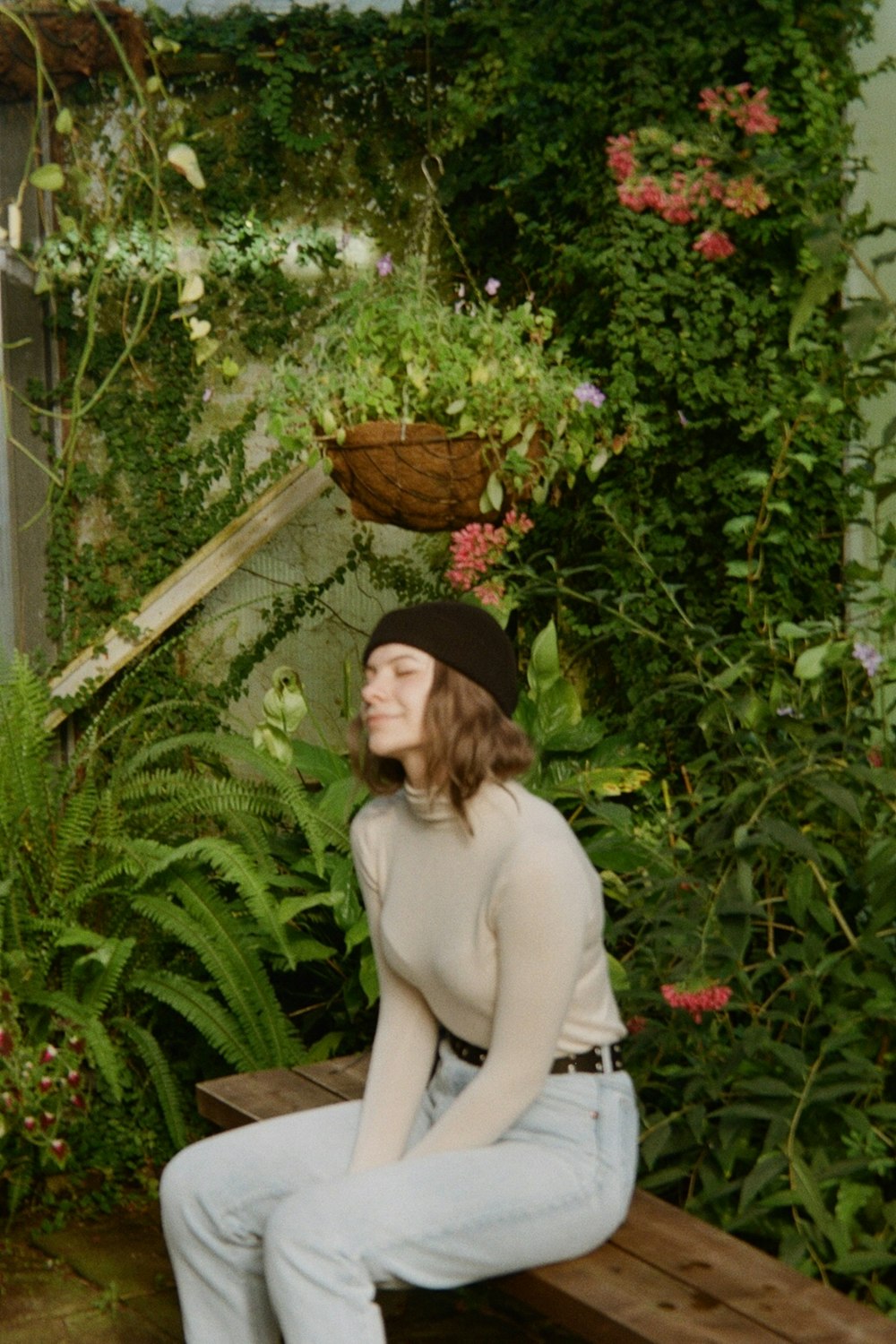 a woman sitting on a bench in a garden