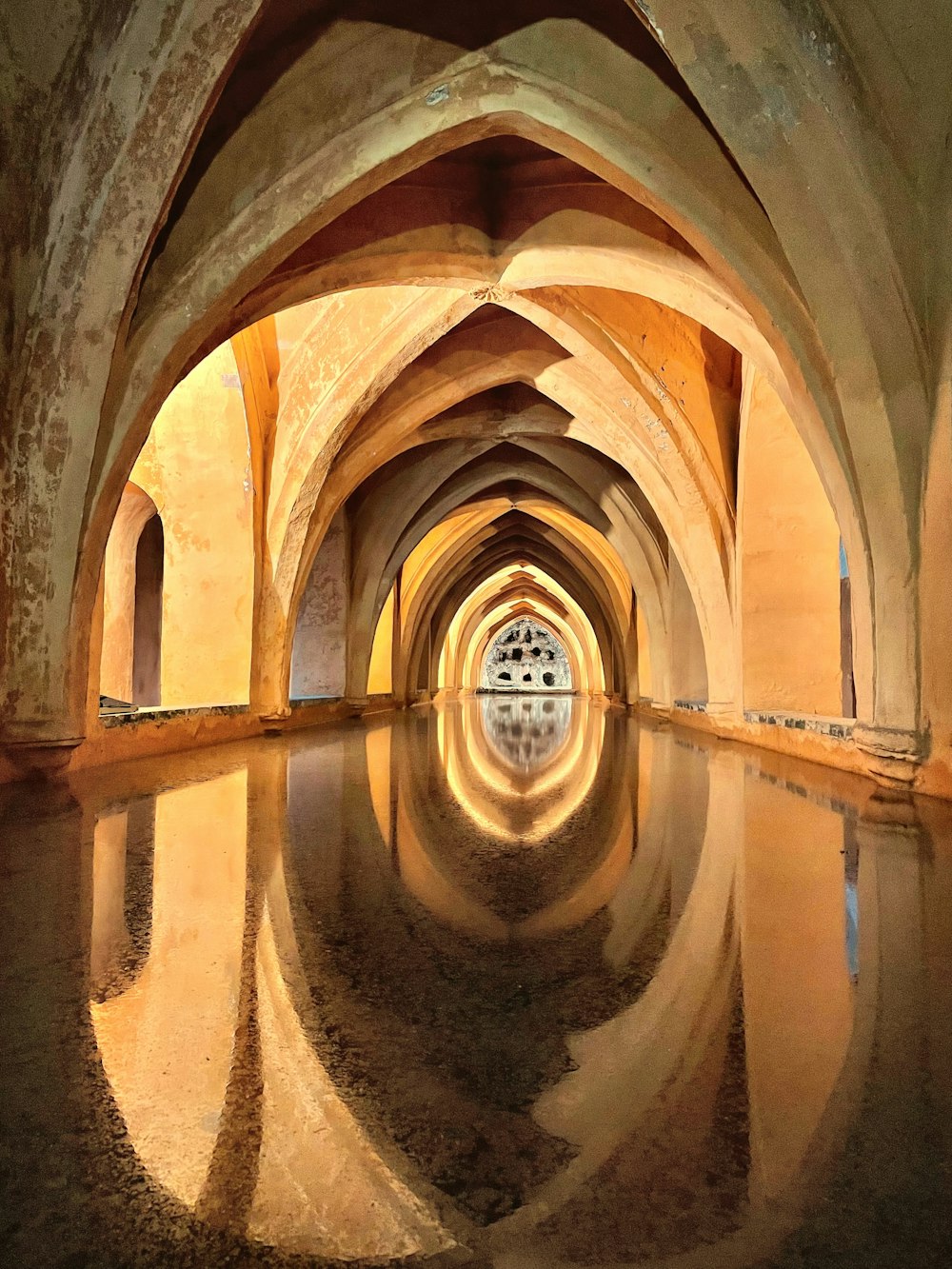 um longo túnel com um reflexo na água