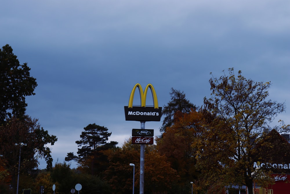 a mcdonald's sign and a mcdonald's sign on a cloudy day