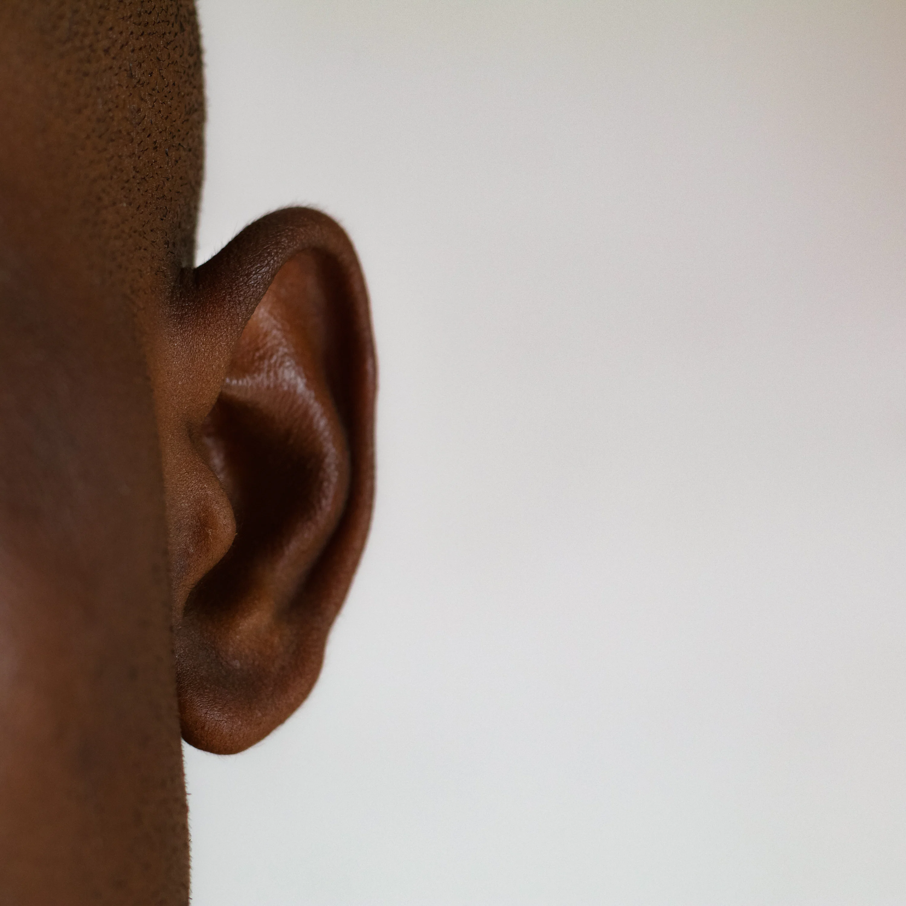 a close up of a person's ear with a white background