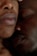 Close-up view of two people resting intimately with their faces closely nestled together. The soft lighting accentuates the texture and warmth of their skin, conveying a sense of comfort and closeness.