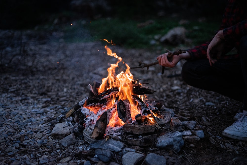 a person sitting in front of a camp fire