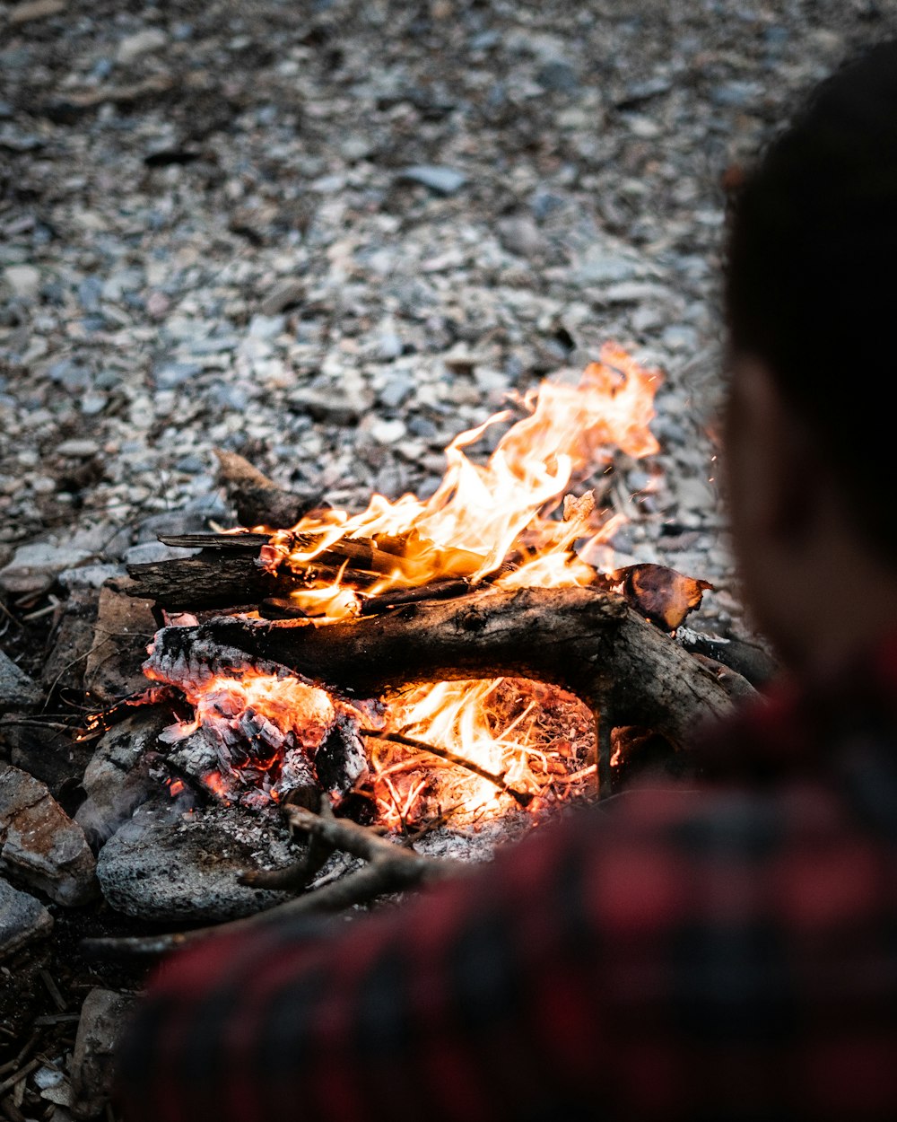 Un homme assis devant un feu de camp