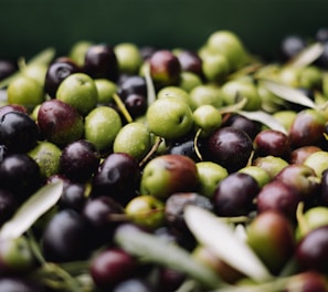 a pile of green and black olives sitting on top of each other