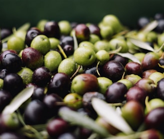 a pile of green and black olives sitting on top of each other