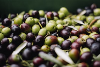 a pile of green and black olives sitting on top of each other