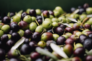 a pile of green and black olives sitting on top of each other