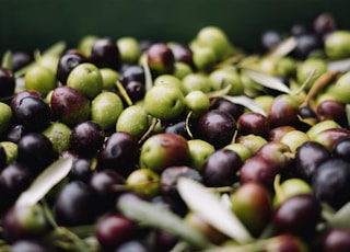 a pile of green and black olives sitting on top of each other