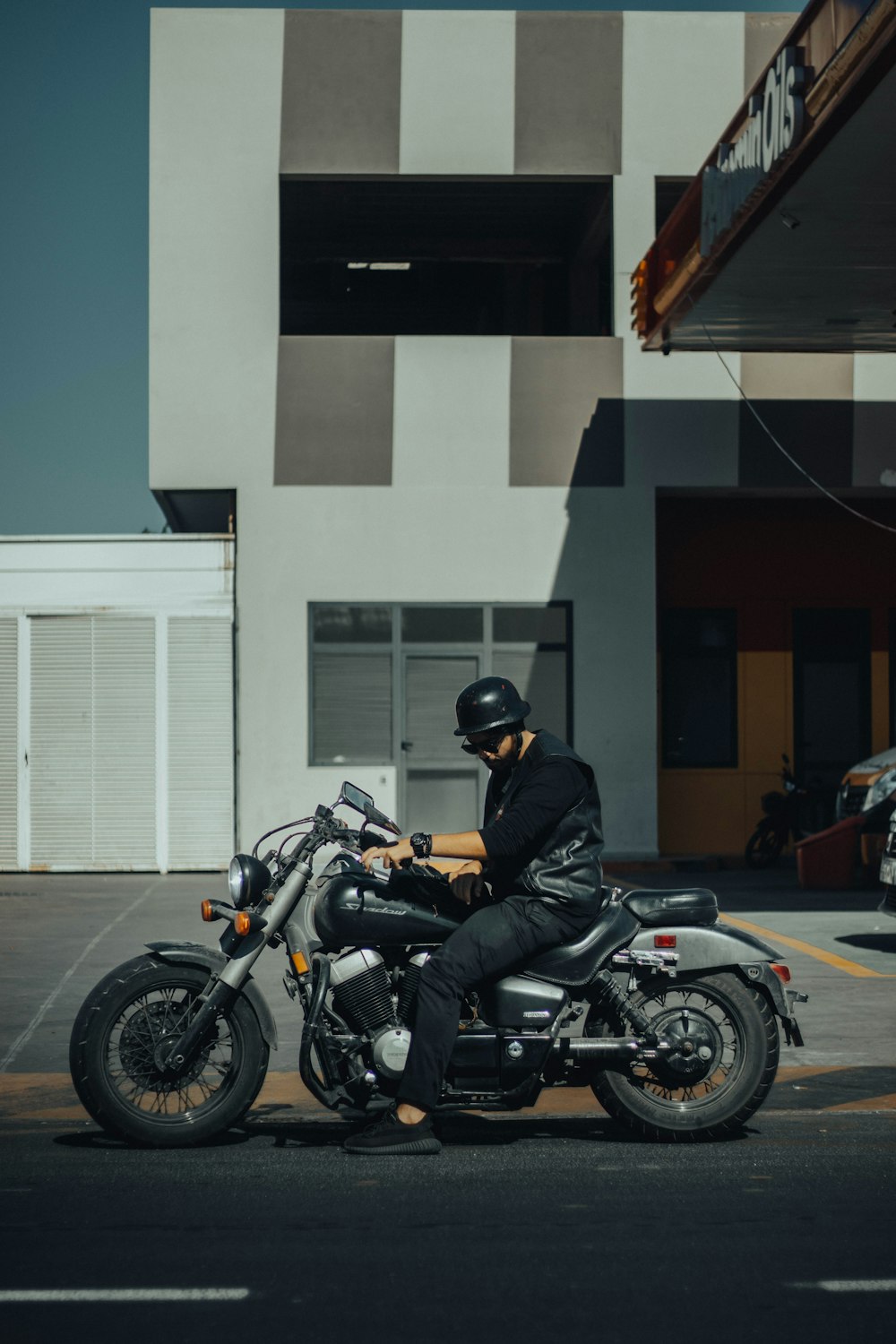 a man sitting on a motorcycle in a parking lot