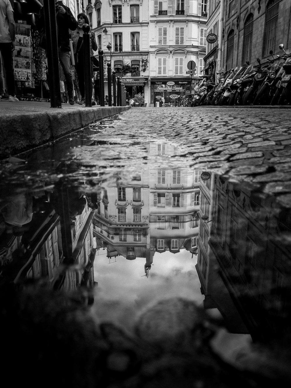 a reflection of a building in a puddle of water