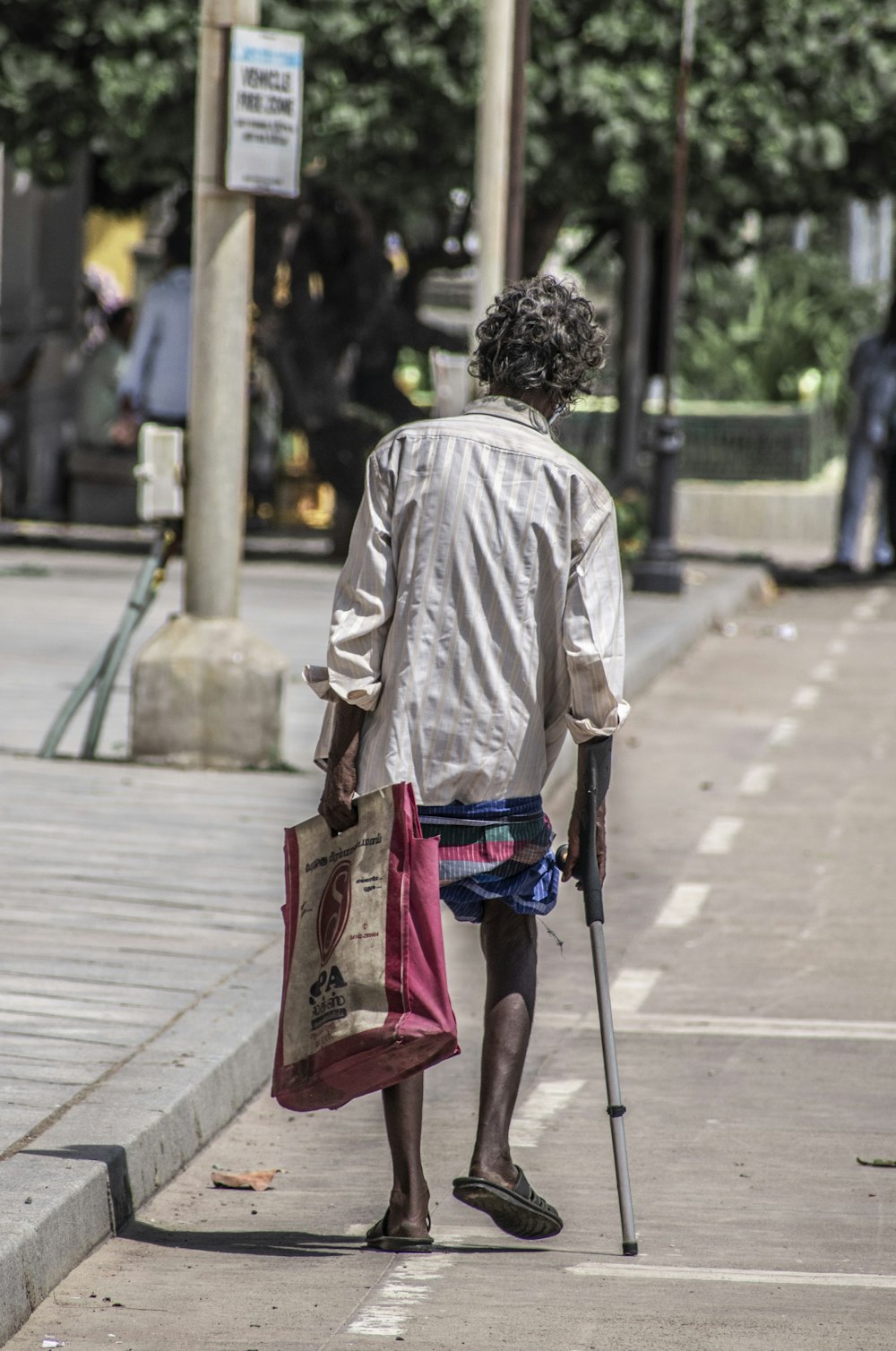 a man walking down the street with a cane