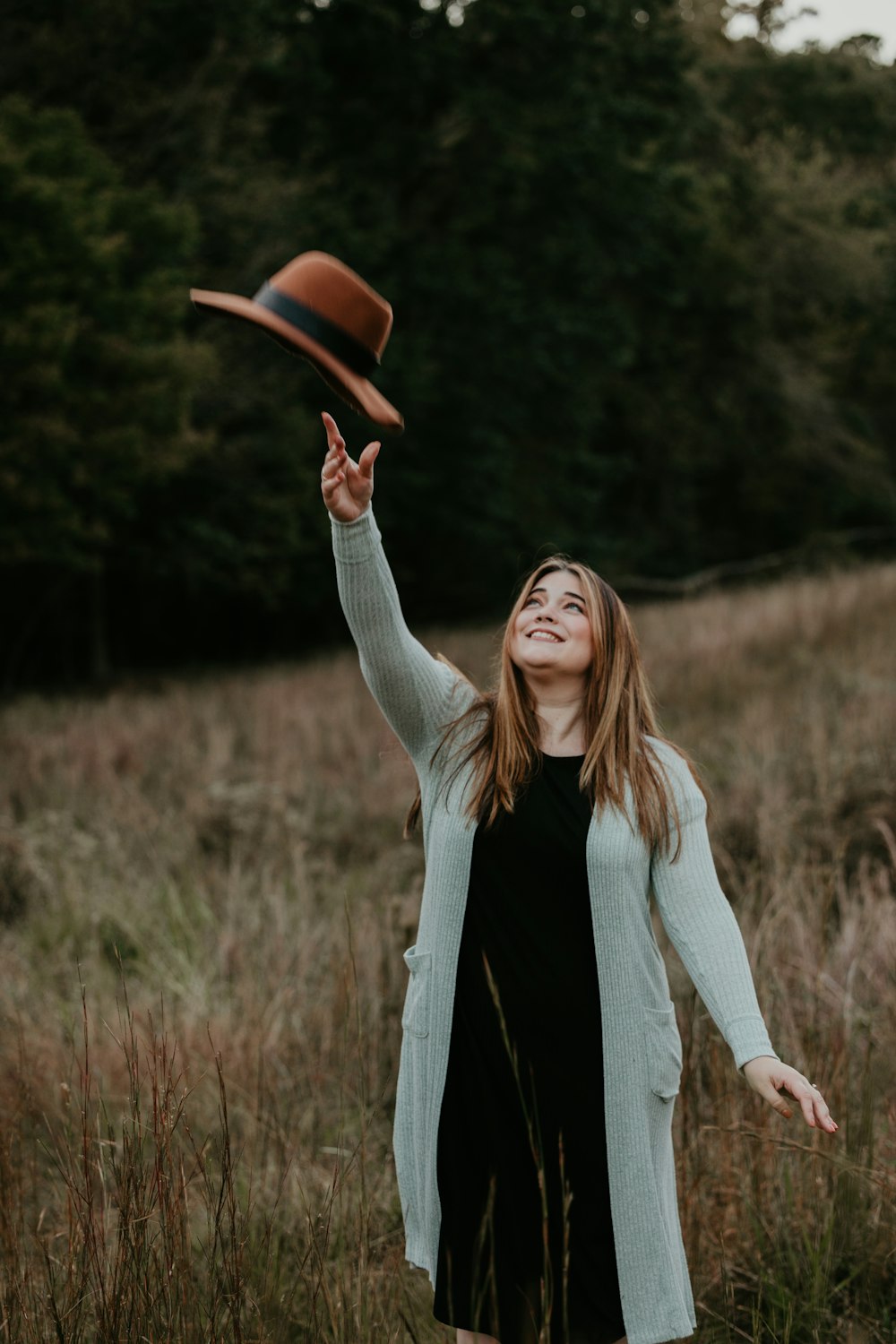 a woman in a black dress and a brown hat