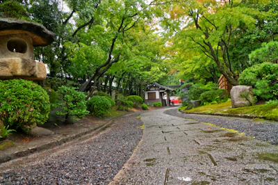 A serene Okinawan garden with lush greenery and a small stone path.