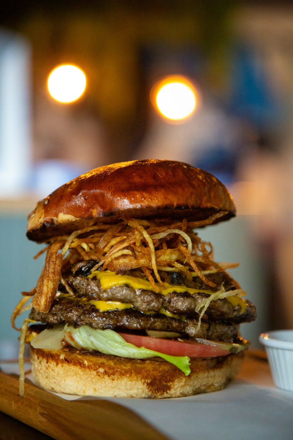 a large hamburger sitting on top of a wooden cutting board