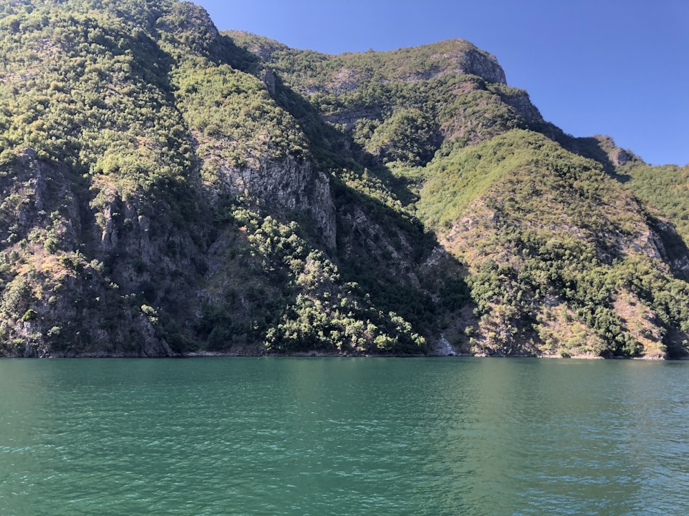 a large body of water with a mountain in the background