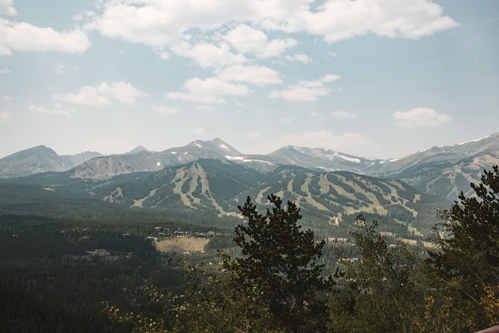 a view of a mountain range with trees in the foreground