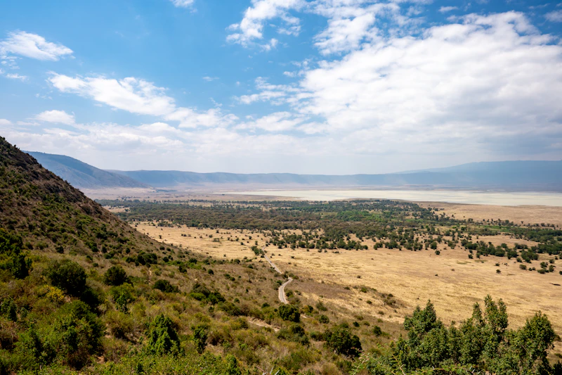 A scenic view across a green valley to distant mountains in the Ngorongoro highlands, Tanzania