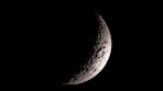 a half moon is seen in the dark sky