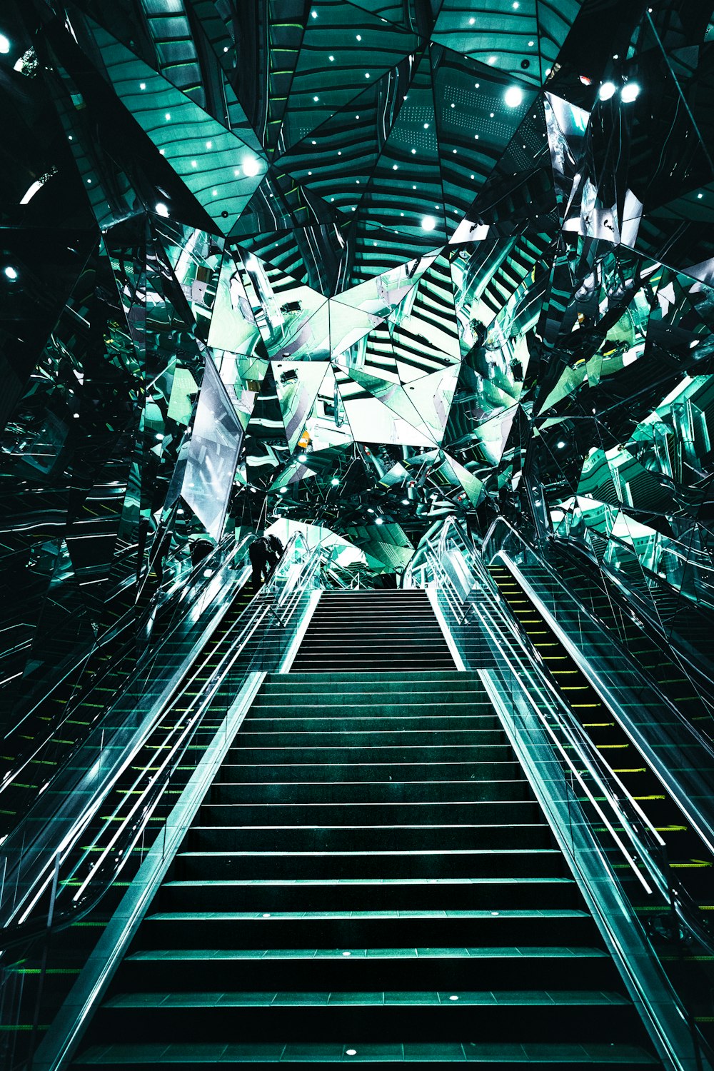 un escalator dans un bâtiment avec beaucoup de miroirs dessus