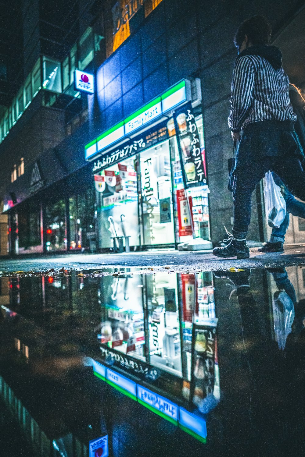 a man walking down a street next to a tall building