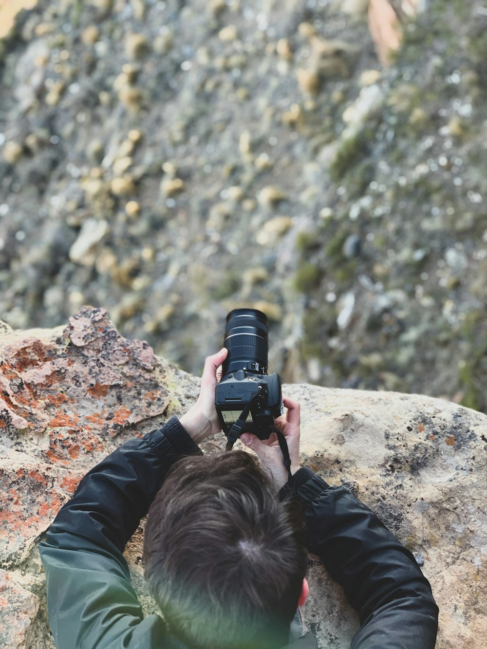 a man taking a picture of a rock with a camera