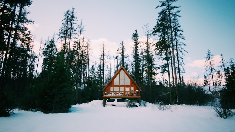 a car parked in the snow in front of a cabin