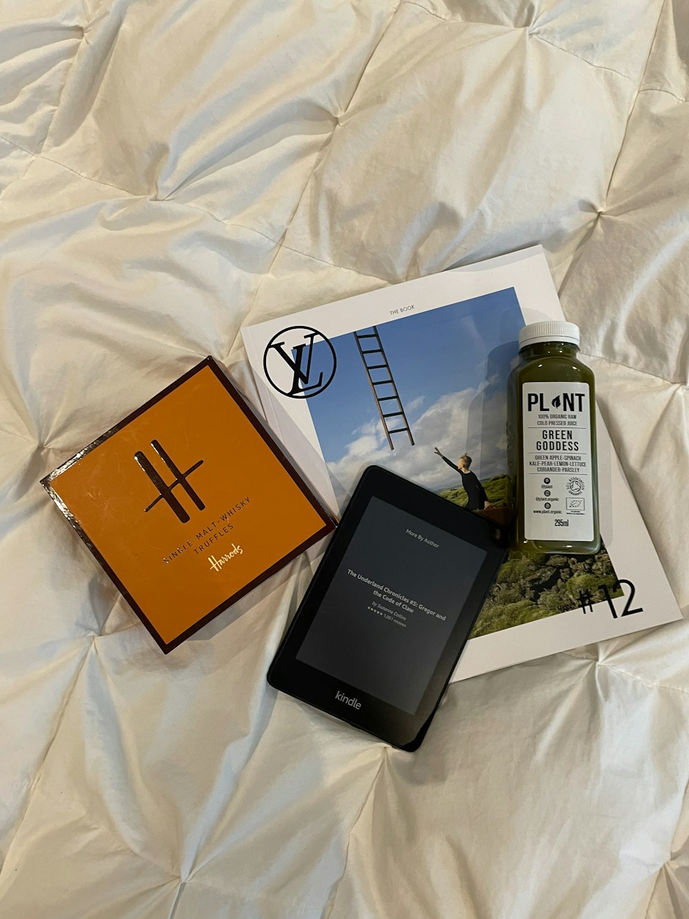 a cell phone and a book on a bed