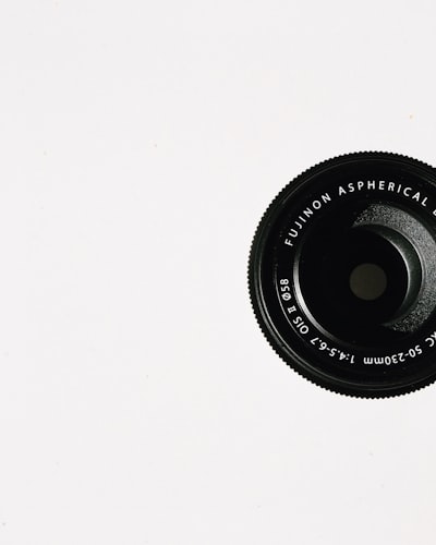Close-up of a camera lens on a white background representing digital imaging and photo file format structure