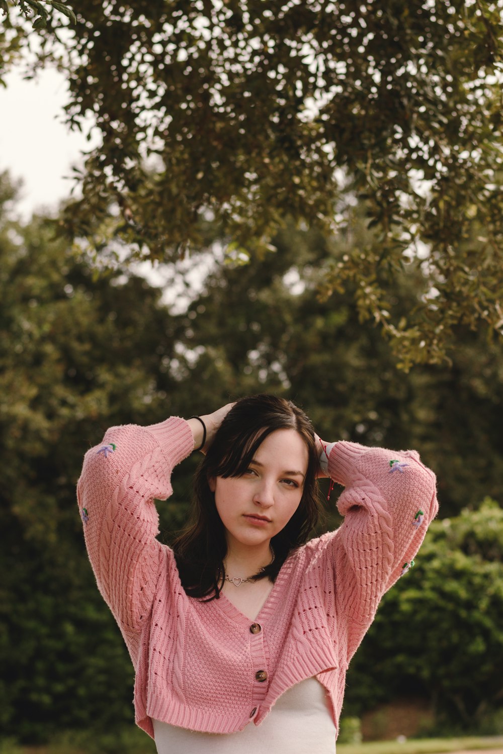 a woman in a pink sweater and white skirt