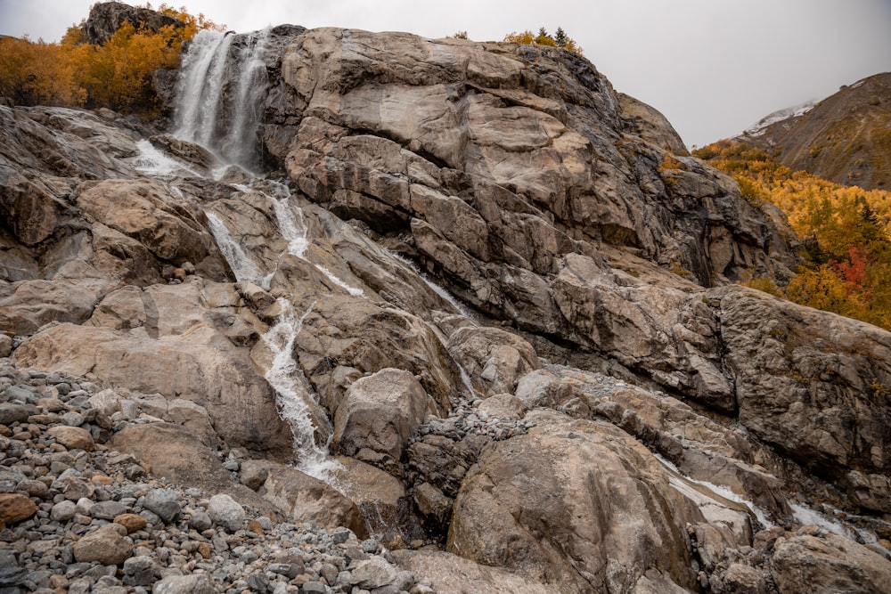 a waterfall is coming down a rocky hill