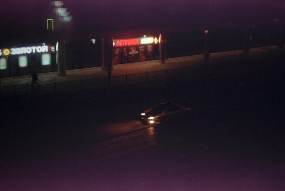 a car driving down a street at night