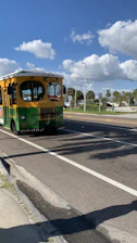 A colorful local bus driving through a sunny street in Santo Domingo Antioquia.