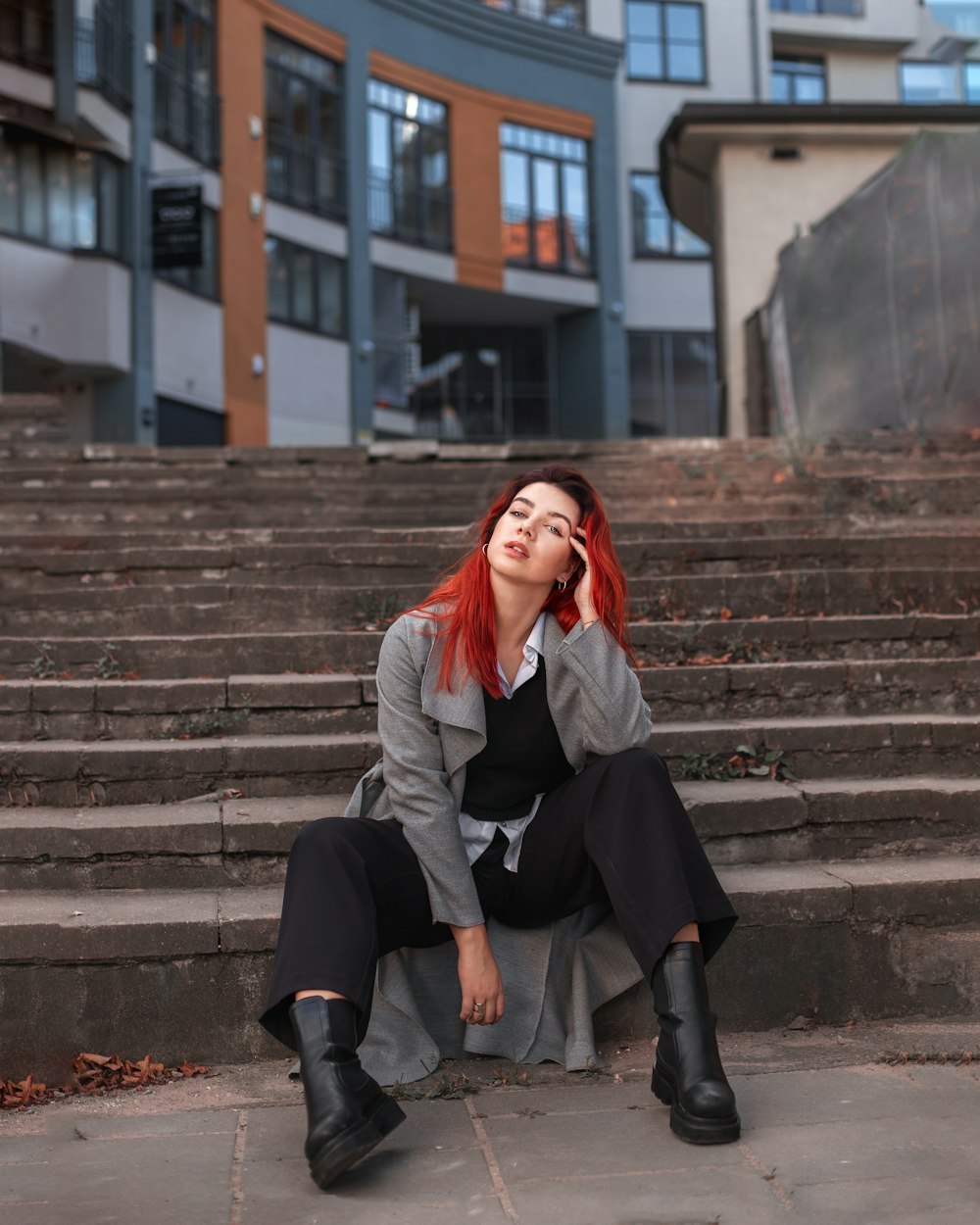 a woman with red hair is sitting on the steps