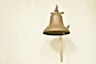 a bell hanging on a wall with a rope