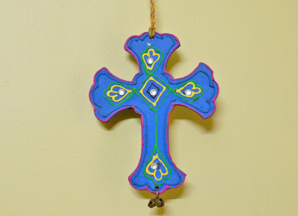 a blue and green cross hanging on a wall