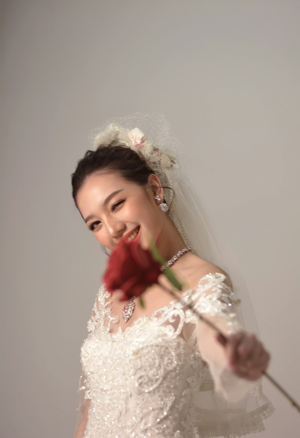 a woman in a wedding dress holding a rose