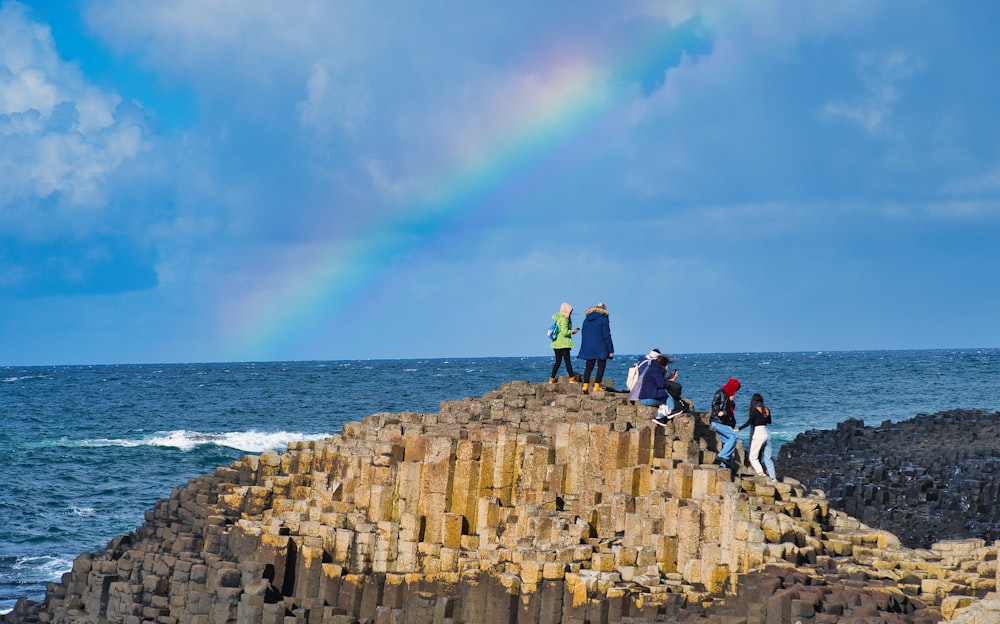 a group of people standing on top of a rock formation