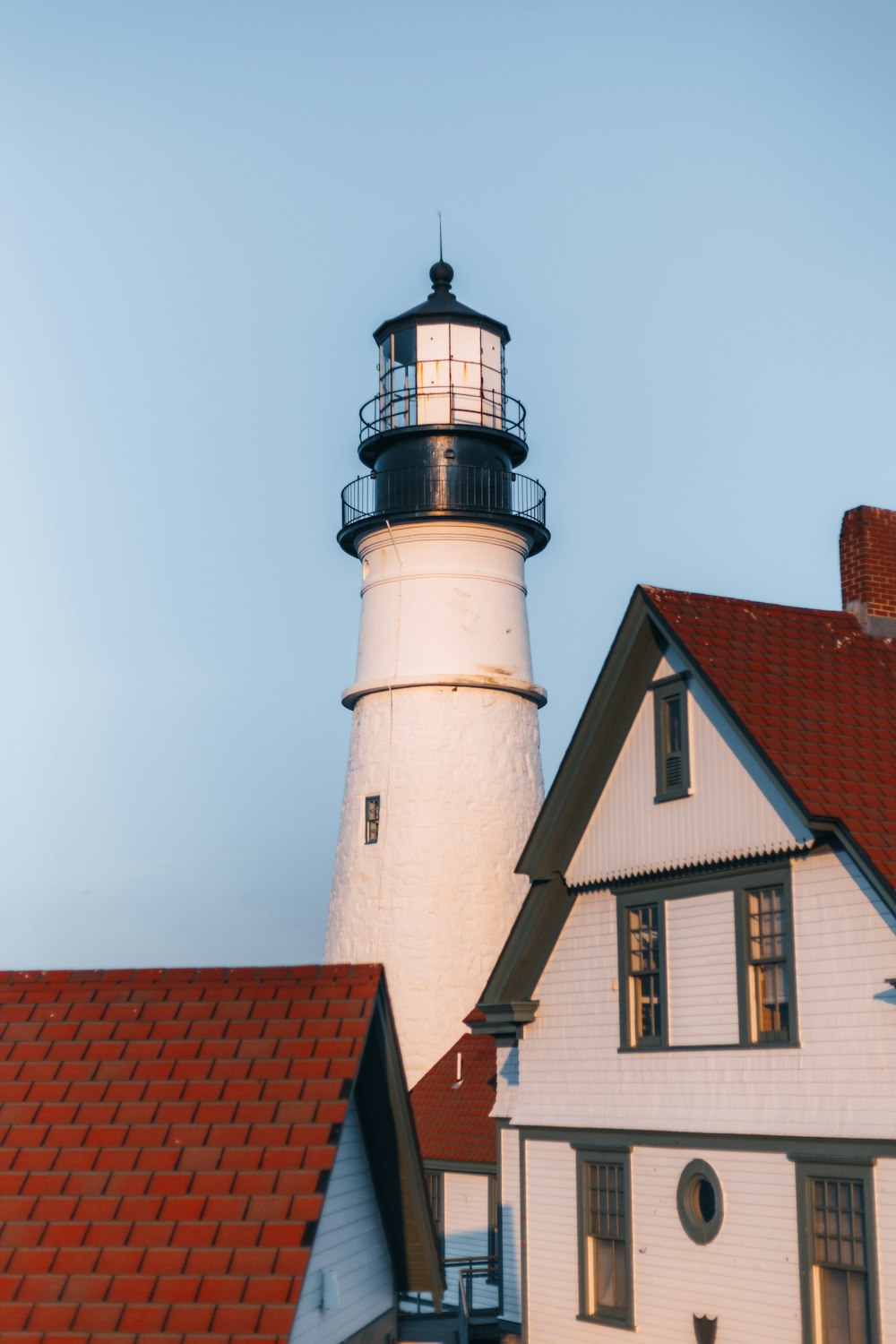 a white house with a black and white lighthouse