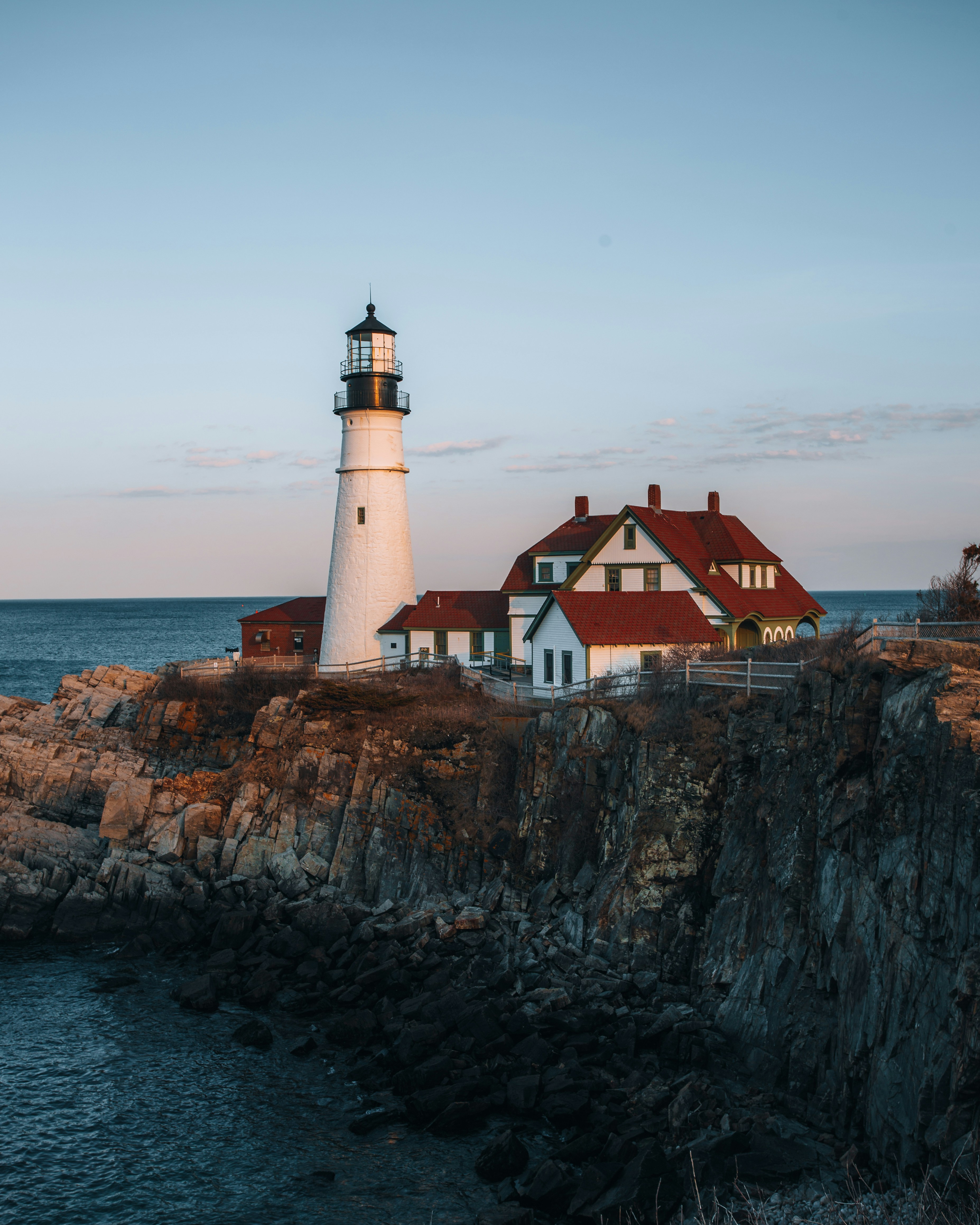 a lighthouse on a rocky cliff near the ocean